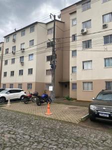 two motorcycles parked in front of a large building at Apartamento térreo bem equipado, fácil acesso in Canoas