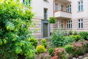 a garden in front of a building at Grey Champagne Spa by Secret Apartament in Gdańsk