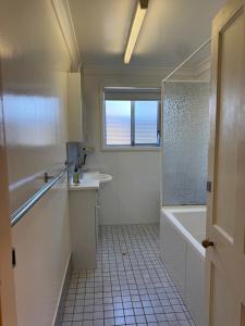 a bathroom with a tub and a sink and a shower at Lake Macquarie holidays in Marks Point +89 photos