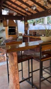 a kitchen with a wooden table and a counter top at Pousada Vertente das Águas in Lumiar