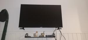 a flat screen tv on a shelf with a cat statue at Departamento Pucon Parque in Pucón
