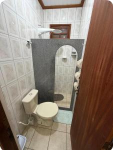 a bathroom with a toilet and a mirror at Aconchego Anjo Helena in Domingos Martins