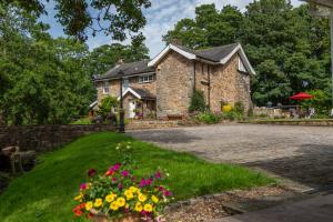 a stone house with flowers in front of it at Picket Post House Accommodation in Catterall