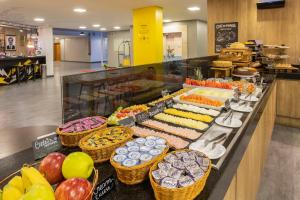 a buffet with many different types of food on display at Hotel Cassino Tower Piracicaba by Nacional Inn in Piracicaba +26 photos