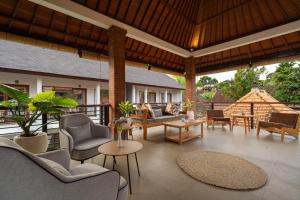 an outdoor patio with chairs and tables at Amantra Ubud in Ubud