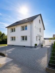 a white house with a gravel driveway at Ferienhaus Bailey in Laupheim