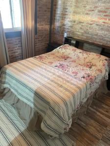 a bed with a blanket on it in a room at Tres Raíces in Miramar +8 photos