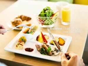 a plate of food on a table with a plate of food at Hotel Intergate Hiroshima in Hiroshima