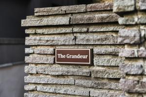 a sign on the side of a brick wall at THE GRANDEUR in Sapporo