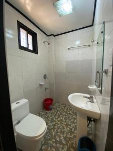 a bathroom with a toilet and a sink at Strangers Inn&Bar in General Luna