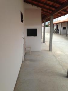 ein weißes Gebäude mit einem TV an der Wand in der Unterkunft Pousada Camacho in Jaguaruna