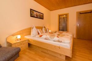 a bedroom with a wooden bed in a room at Ferienwohnung Plozner in Rattendorf