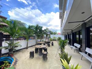 a patio with benches and tables on a building at Strangers Inn&Bar in General Luna