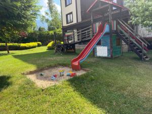 a playground in the yard of a house with a slide at Pirin Getaway Heaven in Razlog
