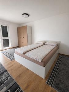 a bedroom with a bed in a white room at Apartment Real in Bugojno
