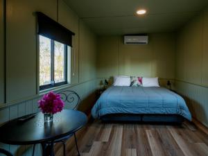 a bedroom with a bed and a table with flowers on it at Longreach Tourist Park in Longreach