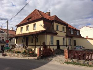 duży biały dom z brązowym dachem w obiekcie Gościniec Król Sielaw w CENTRUM Mikołajek z restauracją regionalną w mieście Mikołajki