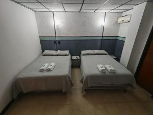 two beds in a small room with towels on them at El santa lucia in Panama City