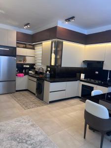 a kitchen with black and white appliances and a table at العلمين الجديدة in El Dab‘a
