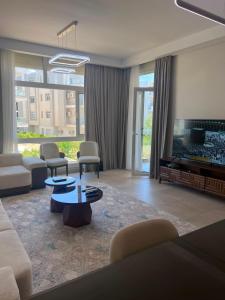 a living room with a couch and a tv at العلمين الجديدة in El Dab‘a