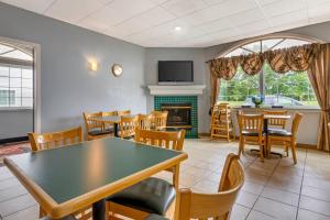 a dining room with tables and chairs and a fireplace at Quality Inn Mauston I-90 in Mauston
