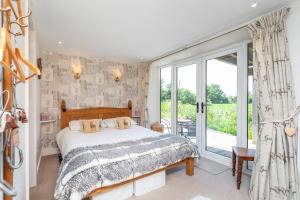 a bedroom with a bed and a large window at Picket Post House Accommodation in Catterall