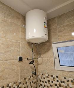 a large white light hanging from the corner of a bathroom at Modern and bright light room in Pasra +26 photos