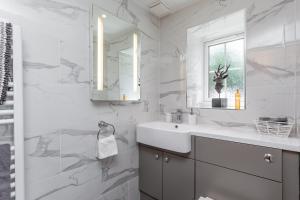 a white bathroom with a sink and a mirror at Picket Post House Accommodation in Catterall +39 photos