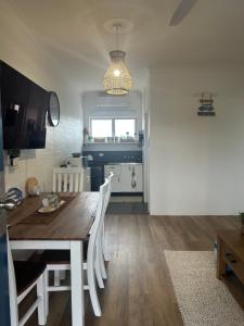 a kitchen and dining room with a wooden table and chairs at Coasters 27 in Sawtell