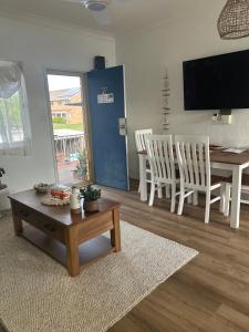 a living room with a table and a dining room at Coasters 27 in Sawtell