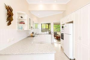 a kitchen with white cabinets and a white refrigerator at Dream Weaver in Bawley Point
