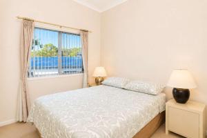 a white bedroom with a bed and a window at Dream Weaver in Bawley Point +10 photos