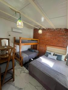 ein Schlafzimmer mit zwei Betten und einer Ziegelwand in der Unterkunft Casa Quinta Jurumi de La Mala Junta in Atyrá + 22 Fotos