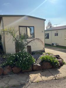 a house with a yard with flowers in front of it at Bacchus Marsh Caravan Park in Bacchus Marsh +4 photos