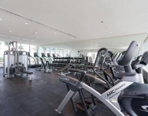 a gym with a lot of treadmills and machines at Sunset View Apartment Deluxe in Honolulu