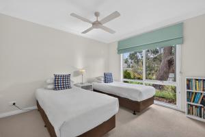 two beds in a bedroom with a window at Foreshore - Spacious Metung Escape in Metung