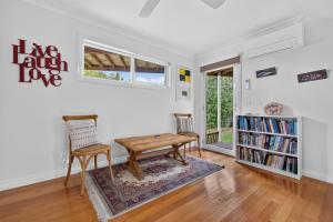 a living room with a table and a chair at Foreshore - Spacious Metung Escape in Metung