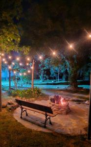 a park bench next to a camp fire at night at Pousada Paraíso Guapi in Guapimirim +22 photos