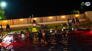 a group of people in the water at night at RB Global Inc and RB Wizzy Ventures in Somanya