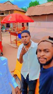 two men standing next to each other on a street at RB Global Inc and RB Wizzy Ventures in Somanya