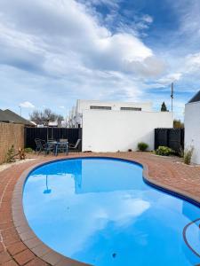 a large blue swimming pool in a yard at Sundowner Motel in Blenheim