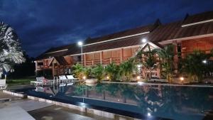 a house with a swimming pool at night at Romantic Vang Vieng resort in Vang Vieng