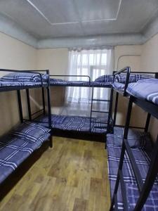 a room with three bunk beds and a window at Ayvan Eco Hostel in Tashkent