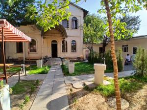 a house with a palm tree in front of it at Ayvan Eco Hostel in Tashkent +18 photos