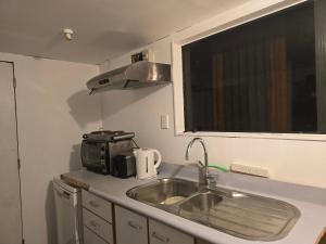 a small kitchen with a sink and a microwave at Affordable pit stop Te Horo Beach in Te Horo