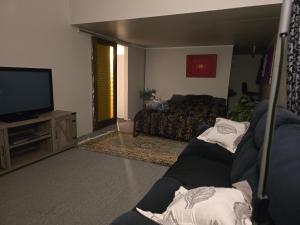 a living room with a couch and a television at Affordable pit stop Te Horo Beach in Te Horo +2 photos