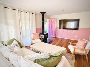 a living room with a white couch and a pink door at Shell Shack in Tomakin