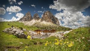 a village in front of a mountain at Passo Sella Dolomiti Mountain Resort in Selva di Val Gardena