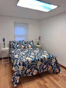 a bedroom with a bed with a floral comforter at Downtown 2 BR Cottage Close to IU in Bloomington