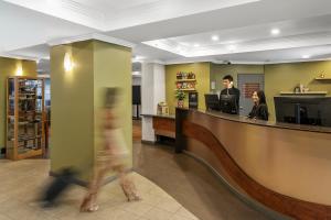 a person walks past a reception desk in a lobby at Mantra Alice Springs in Alice Springs +60 photos